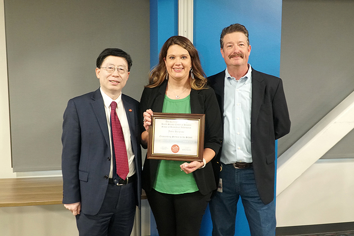 Jaime holding award with Dean Jiajie and Associate Dean Ryan